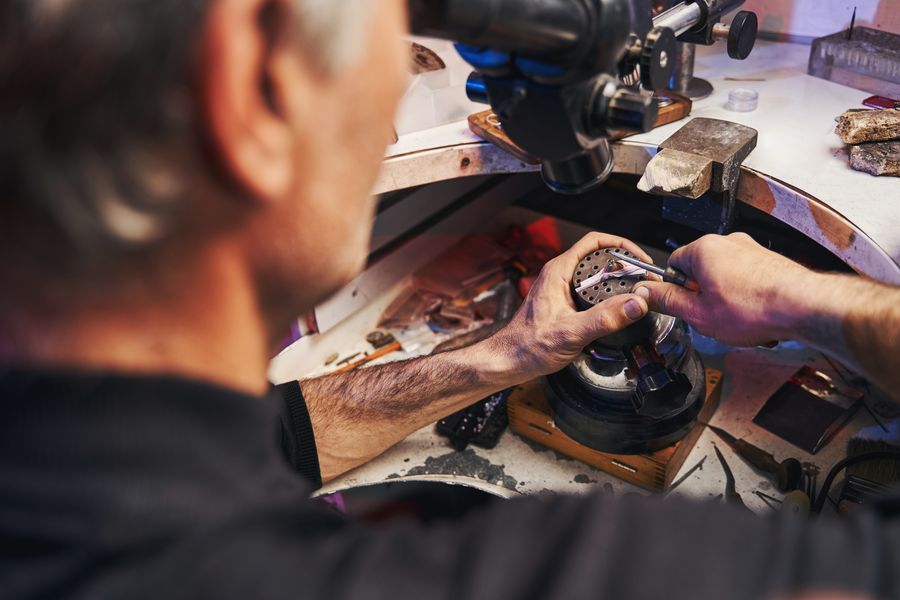 A silversmith working at a jeweler's bench