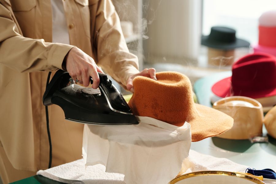 A hatter steaming the brim of a felt hat